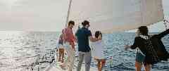 Gothaer Bootshaftpflicht: Junge Leute genießen einen Segel-Törn an der Spitze eines Segelboots